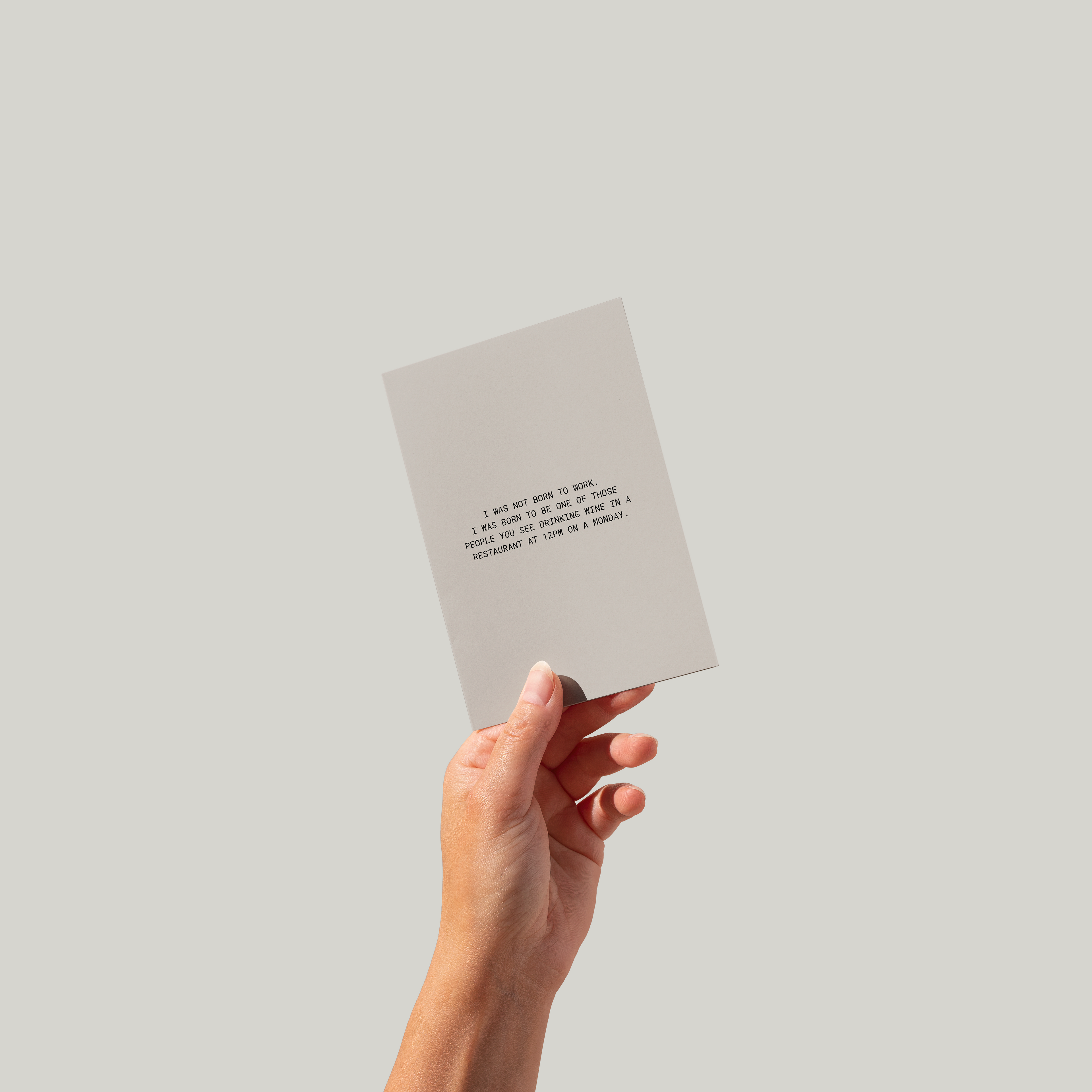 Hand holding a small card with text on a plain background