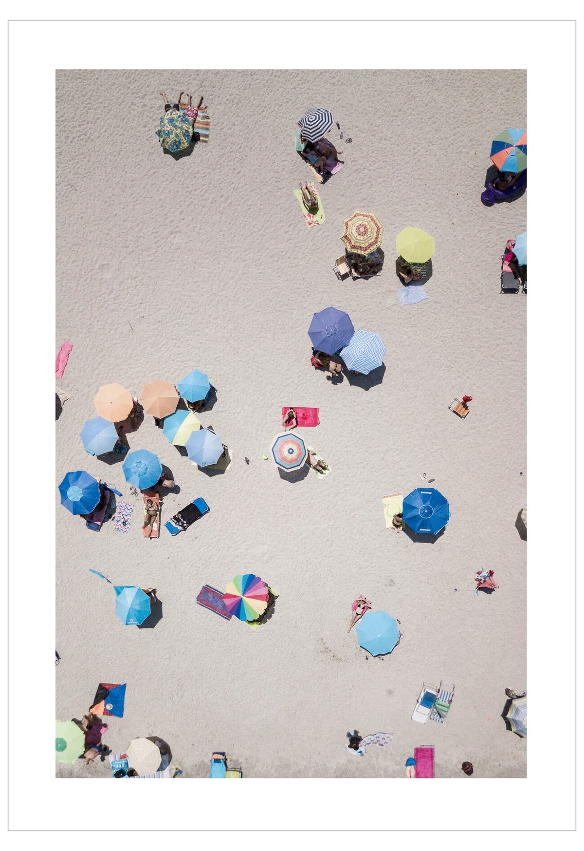 Top-down view of people with colorful umbrellas on a sandy beach.