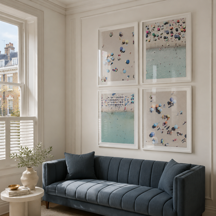Blue sofa in a living room with framed  beach artwork on the wall