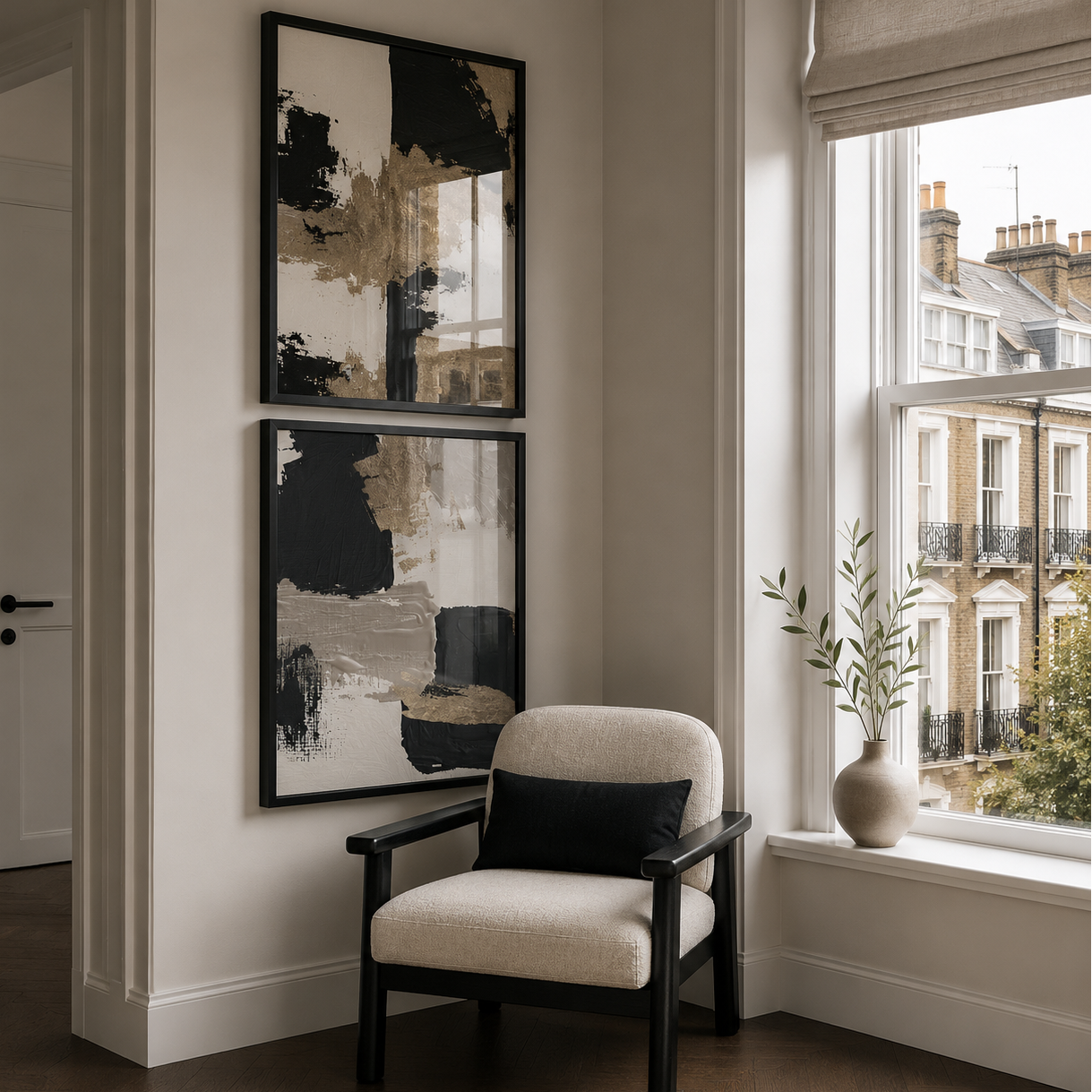Beige armchair with black pillow near a window with abstract wall art