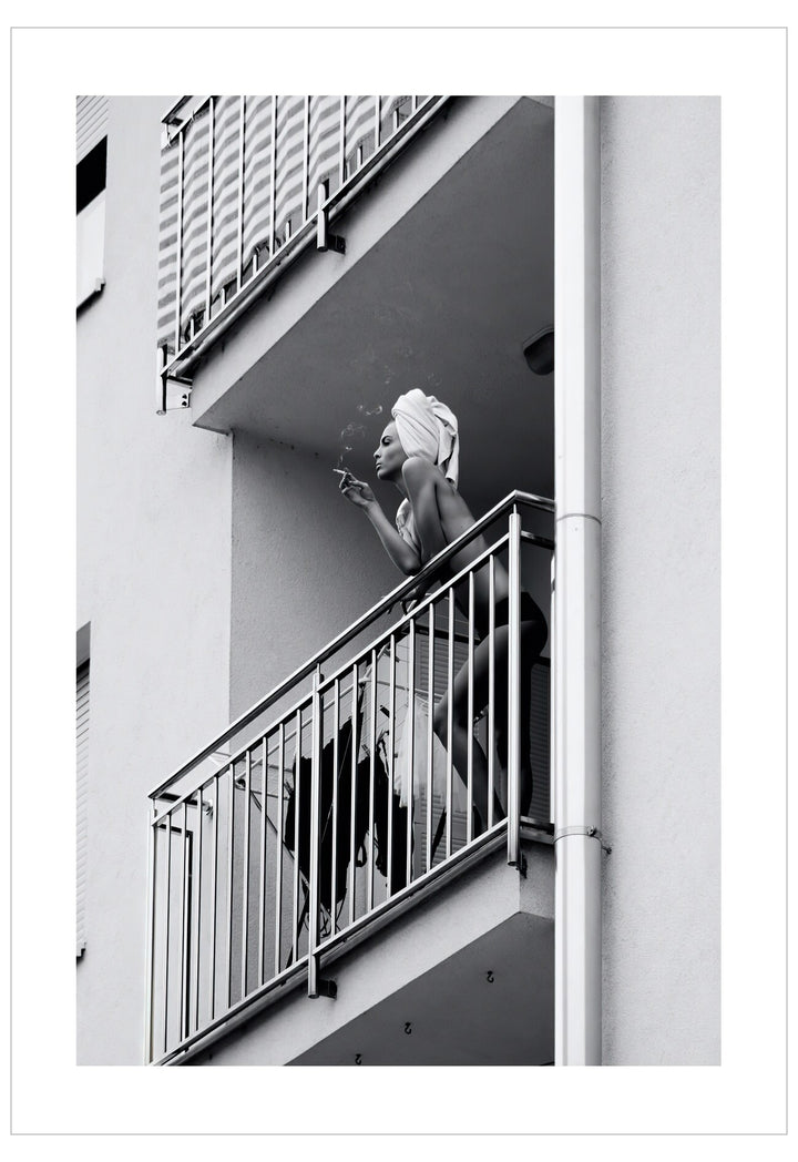 Black and white photo of a woman smoking on a balcony