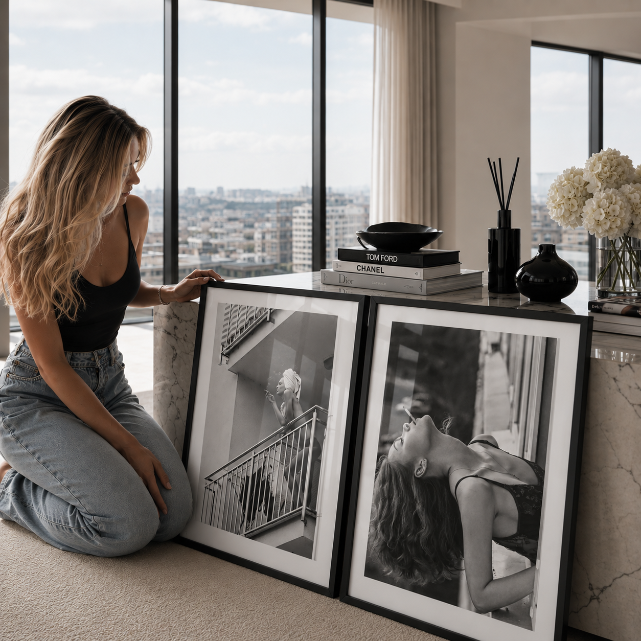 Woman arranging framed photographs in a modern living room with large windows.