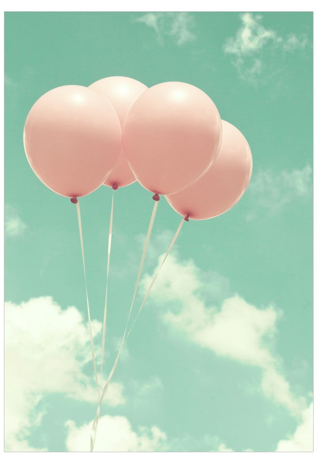 Pink balloons against a light blue sky with clouds