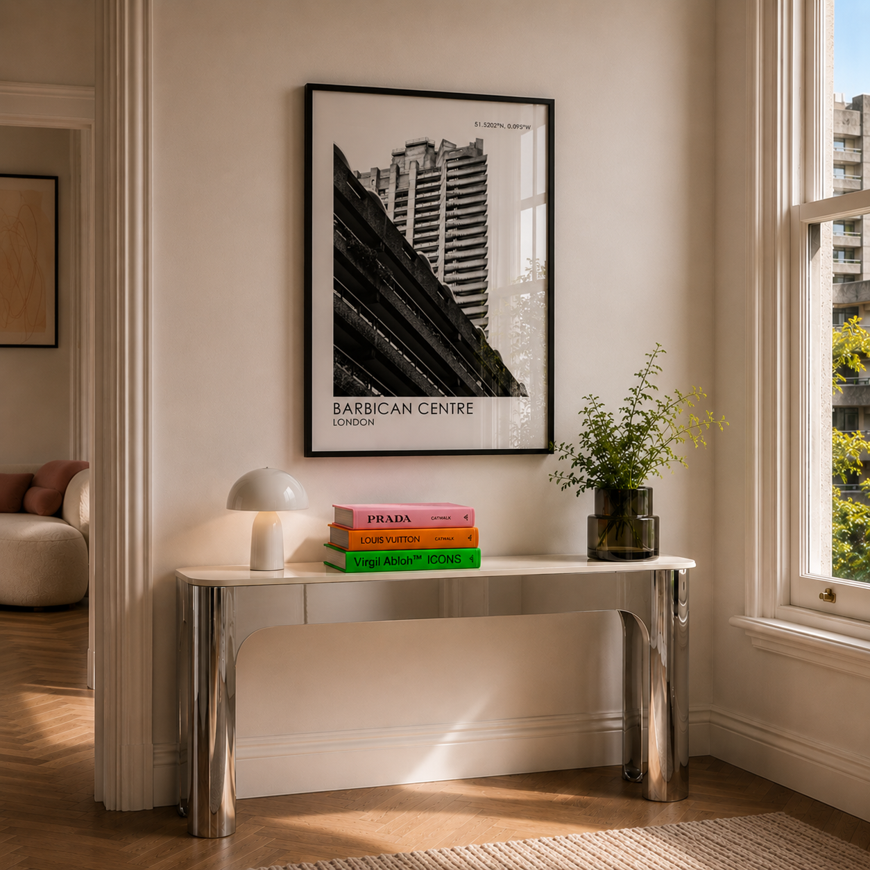 Modern interior with a table, books, and a framed picture of the Barbican Centre.