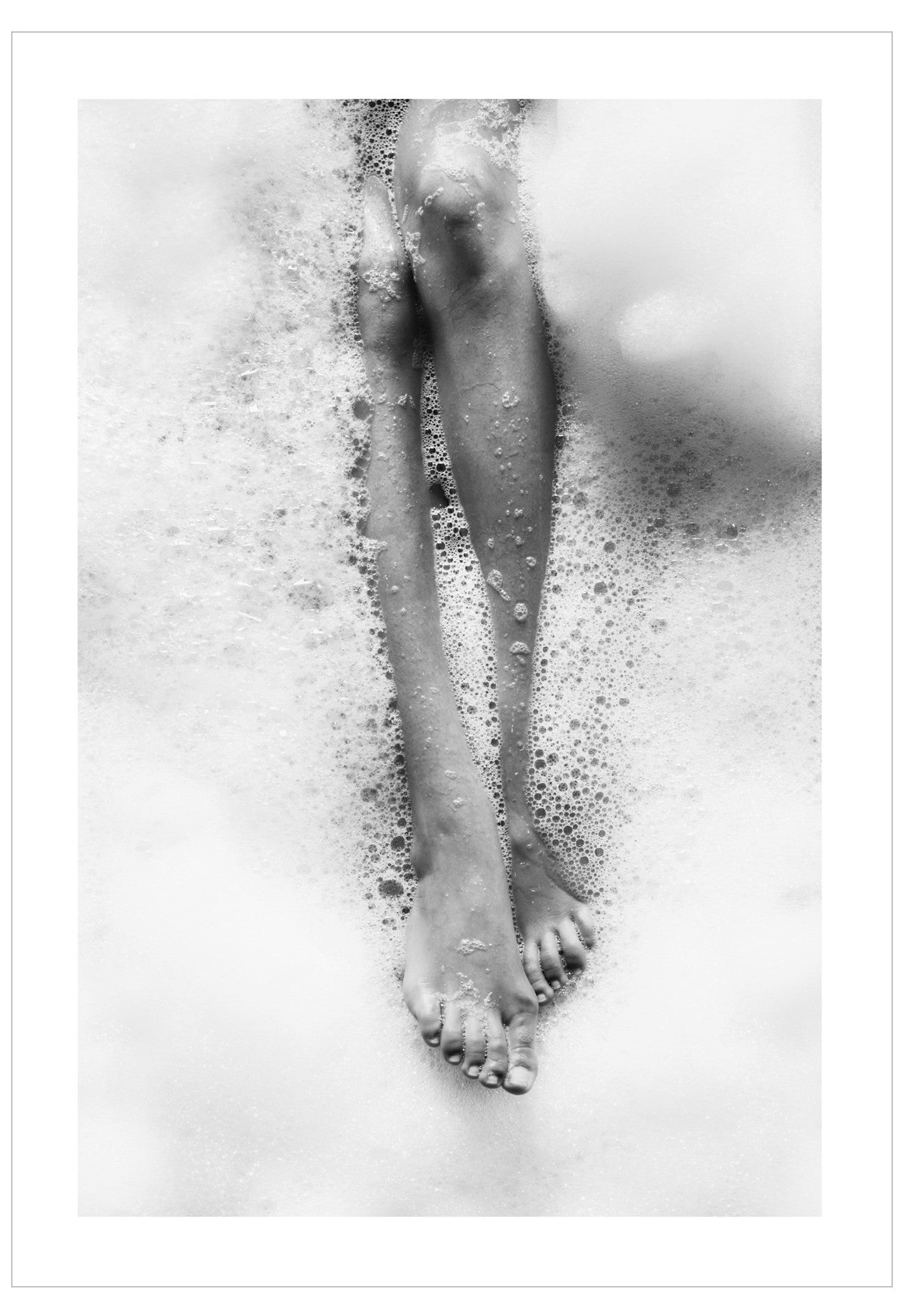 Black and white photo of feet in a bubble bath
