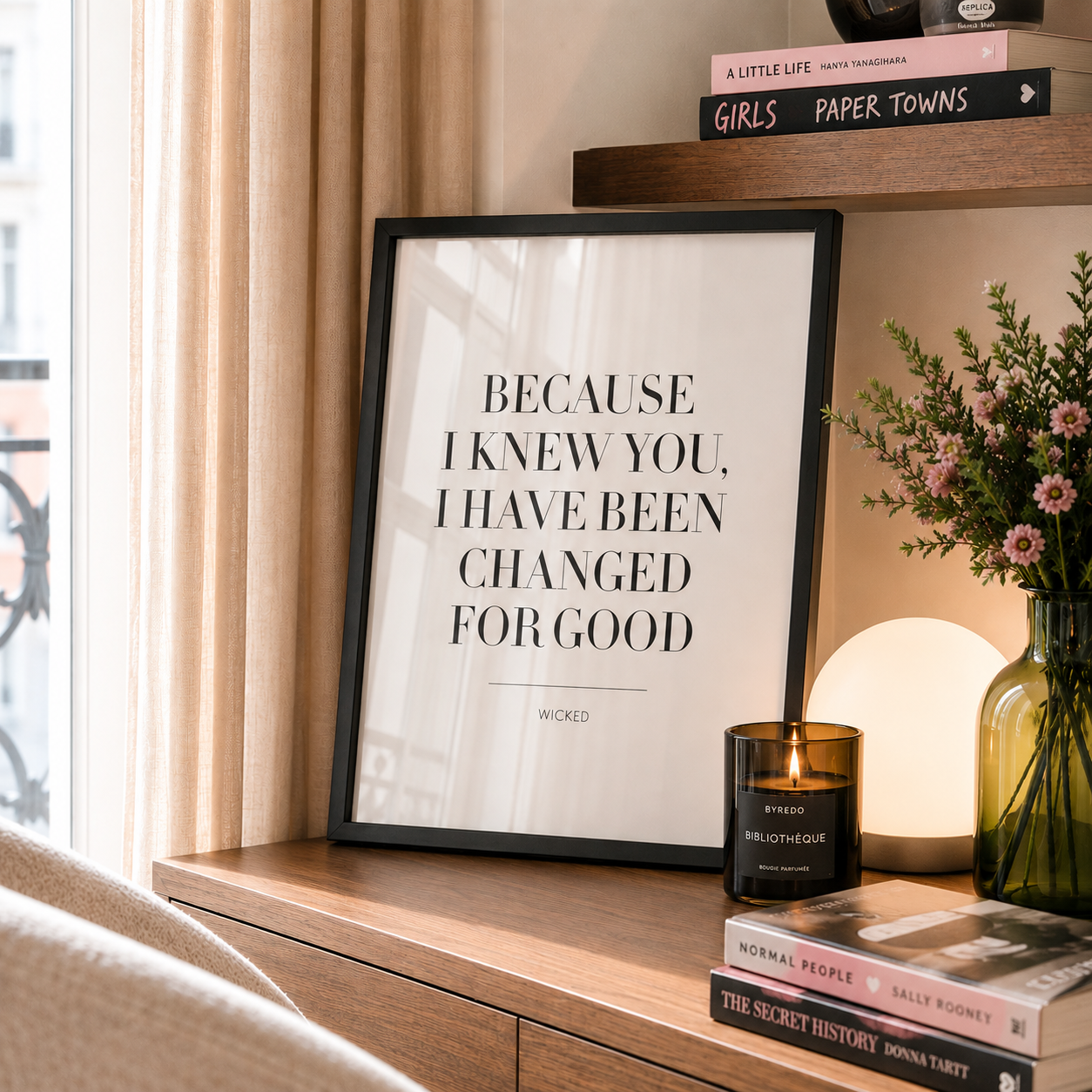 Framed quote on a wooden shelf with books and a candle