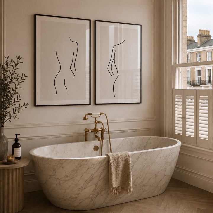 Modern bathroom with marble bathtub, gold fixtures, and abstract art on the wall.