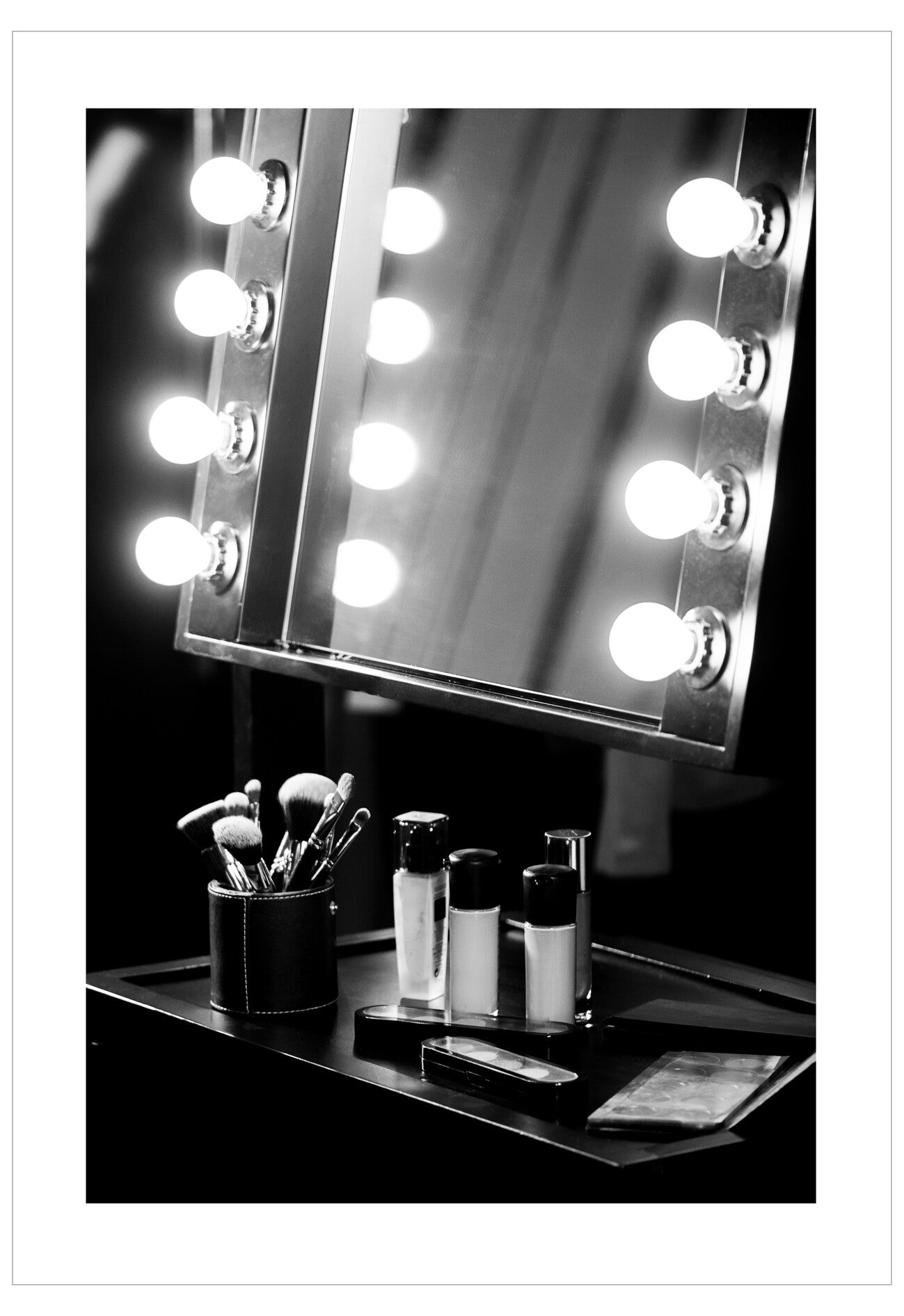 Makeup mirror with lights and various items on a table