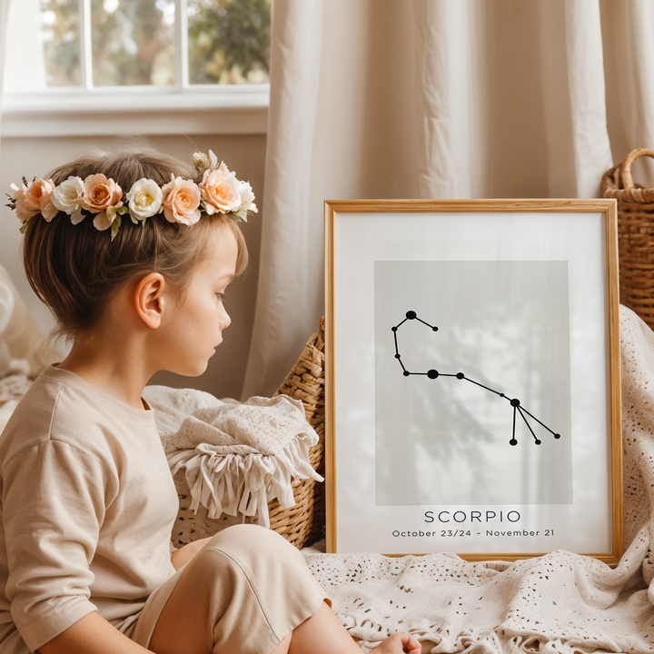 Child with a flower crown sitting next to a framed Scorpio constellation poster in a cozy room.