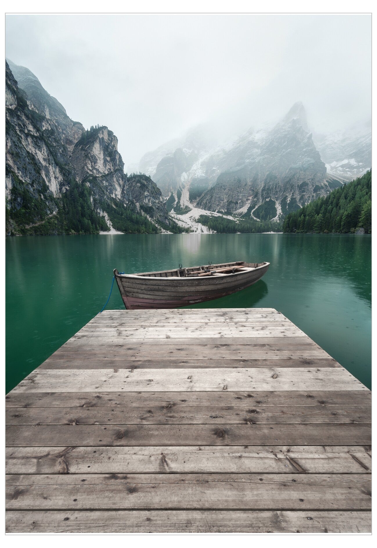 Wooden dock extending into a lake with mountains in the background