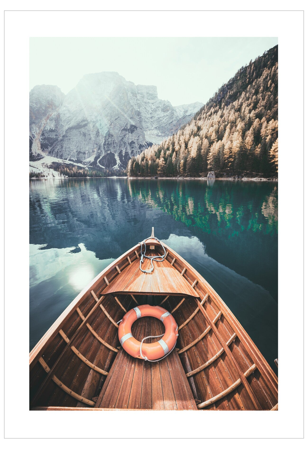 Wooden boat with a life ring on a lake surrounded by mountains and trees