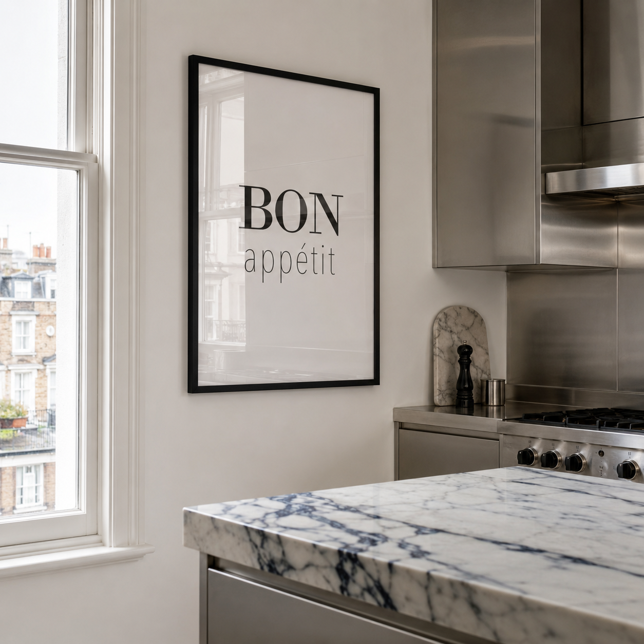 Modern kitchen with marble countertop, stainless steel appliances, and 'Bon appetit' framed text on wall.