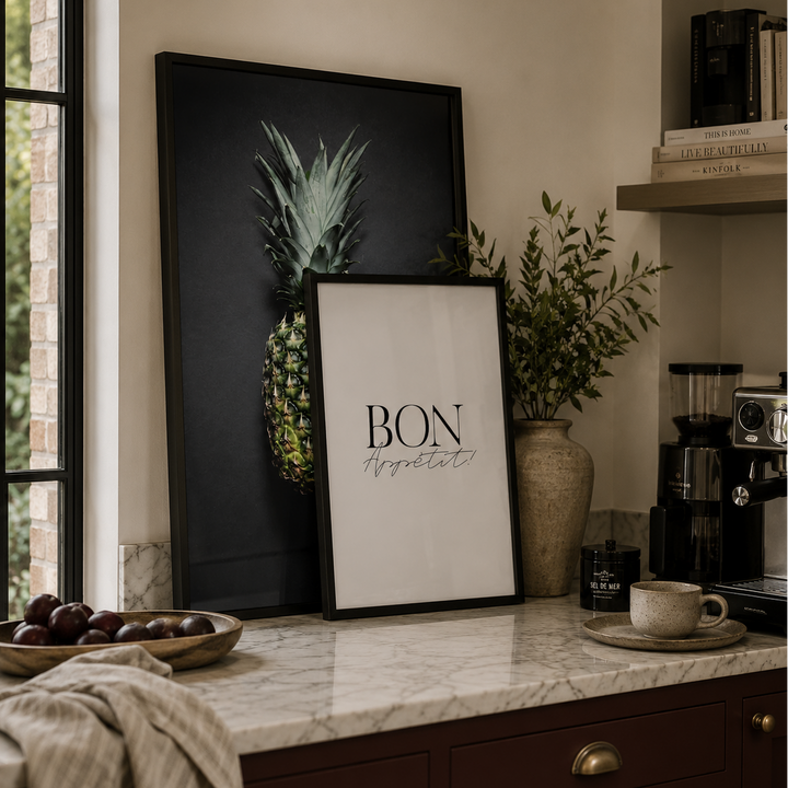 Modern kitchen counter with framed art, plants, and coffee equipment.