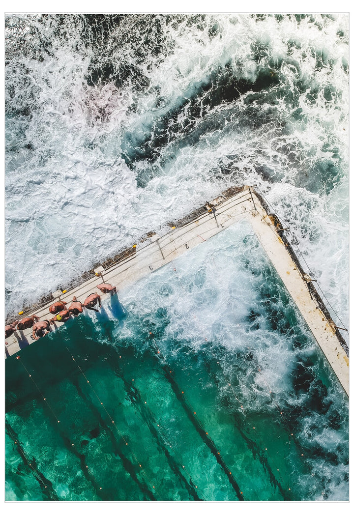 People swimming in a pool with strong waves outside