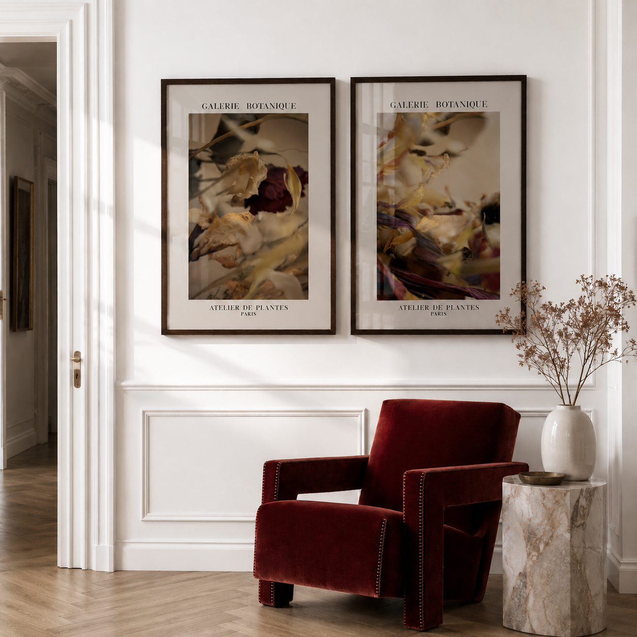 Red armchair in a room with two framed botanical prints on the wall.