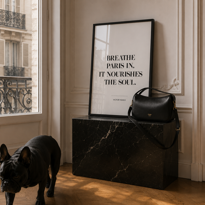 Black marble side table with a black handbag and framed poster in a room with a dog.