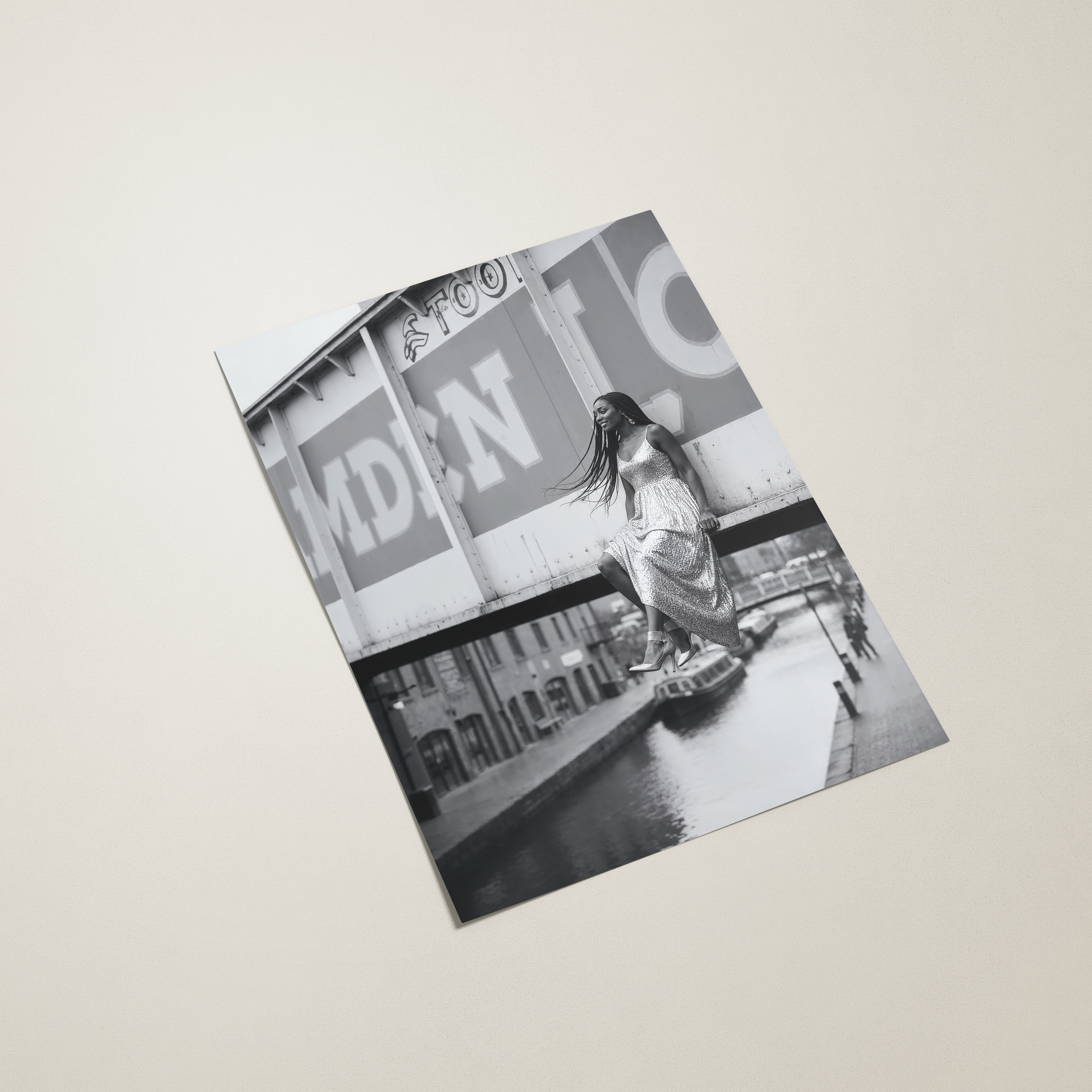 poster with a black and white photo of a person on a city street, placed on a light beige surface.