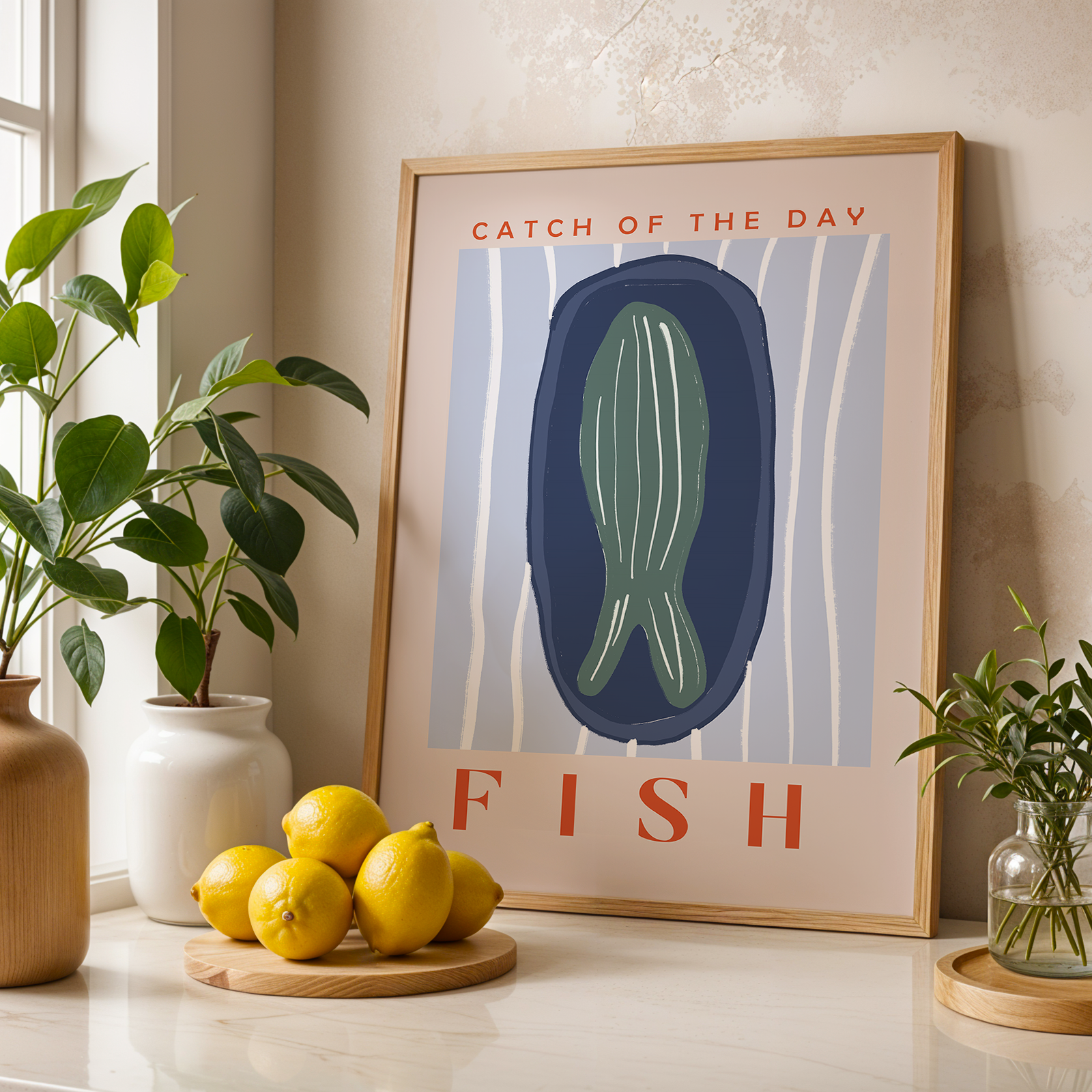 Framed artwork with 'Catch of the Day' and 'Fish' text, lemons, and plants on a table.