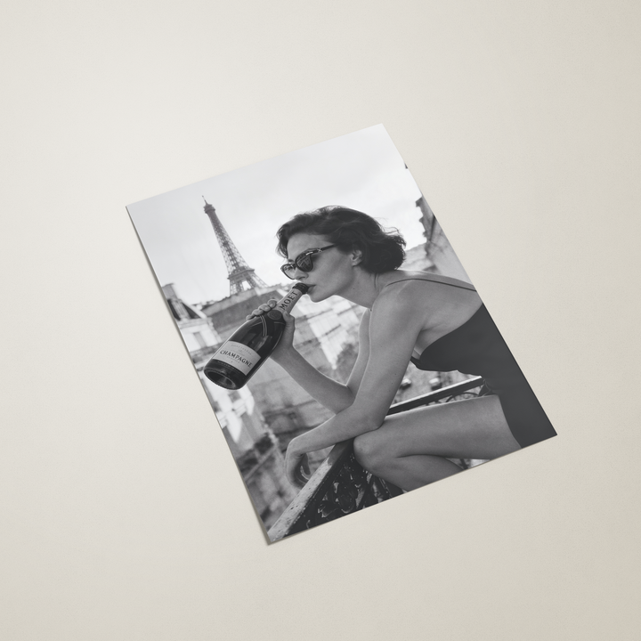 Black and white poster of a woman drinking Moet champagne in Paris on a beige background