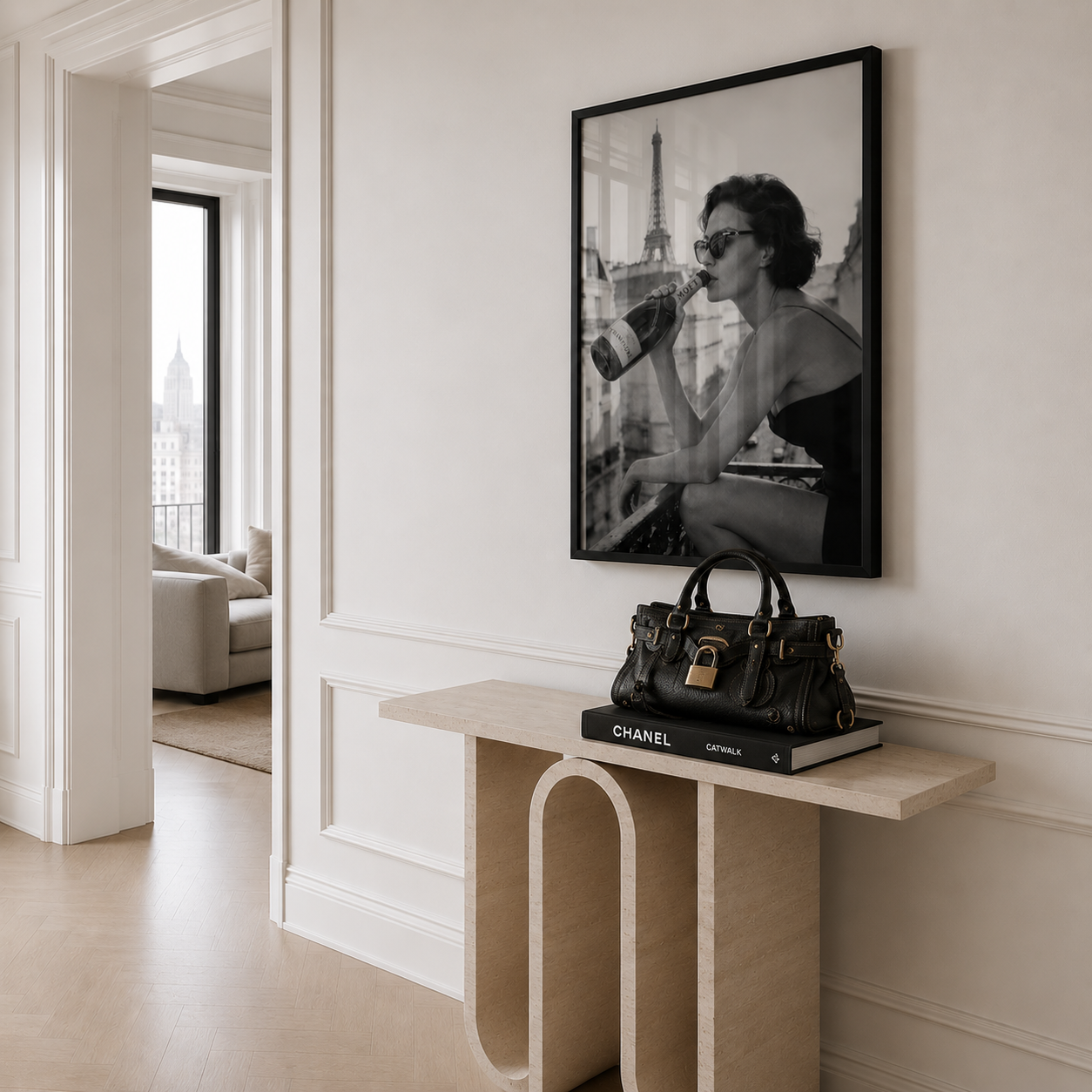 Modern interior with a black handbag and Chanel book on a console table, framed black and white photo of a woman with the Eiffel Tower in the background.