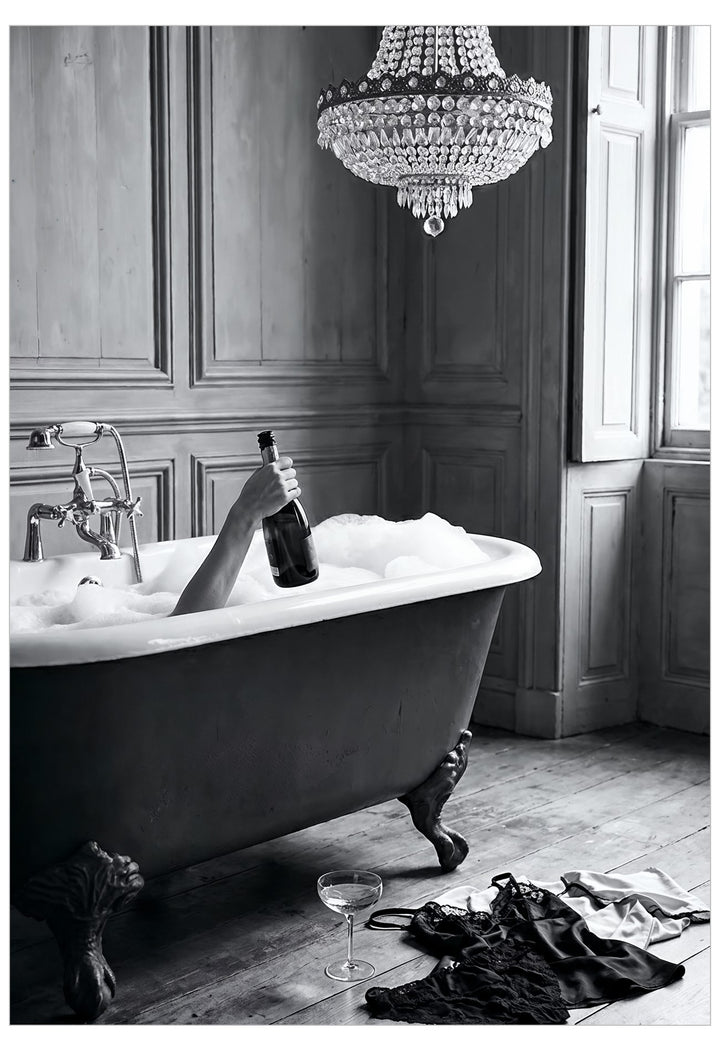 Bathroom with a freestanding bathtub, champagne bottle, and champagne glasses on a wooden floor.