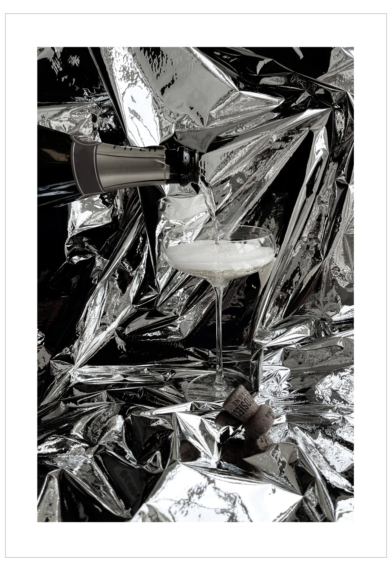 Cocktail glass with a straw on crumpled silver foil