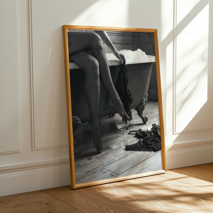 Framed picture of a woman sitting on a roll top bath in black and white