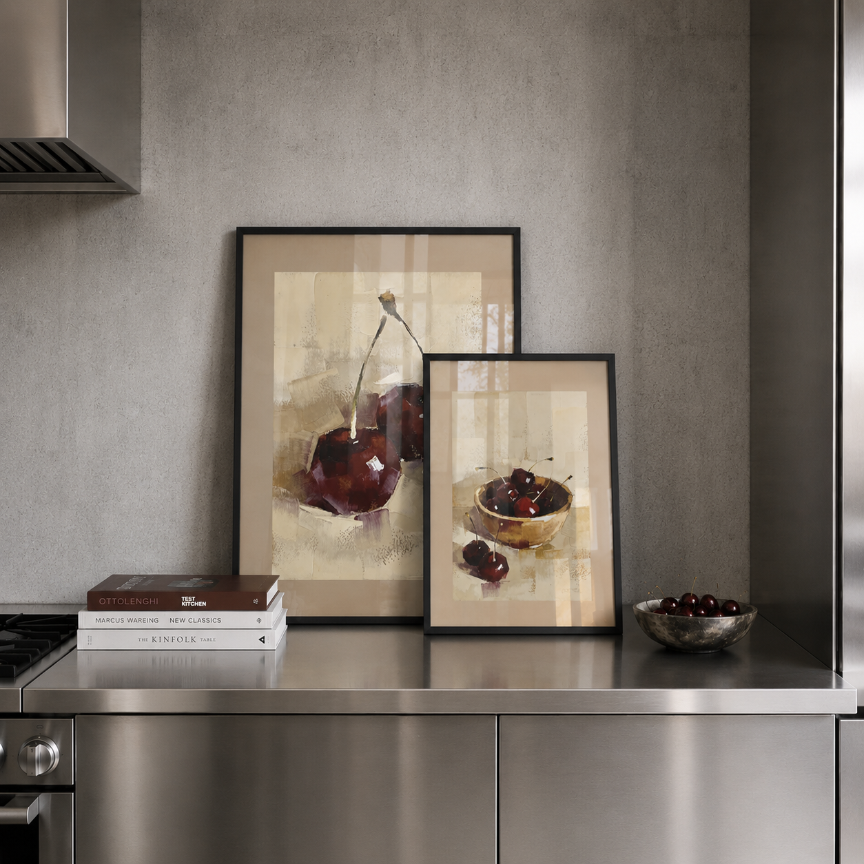 Two framed still life artworks of cherries on a kitchen counter.