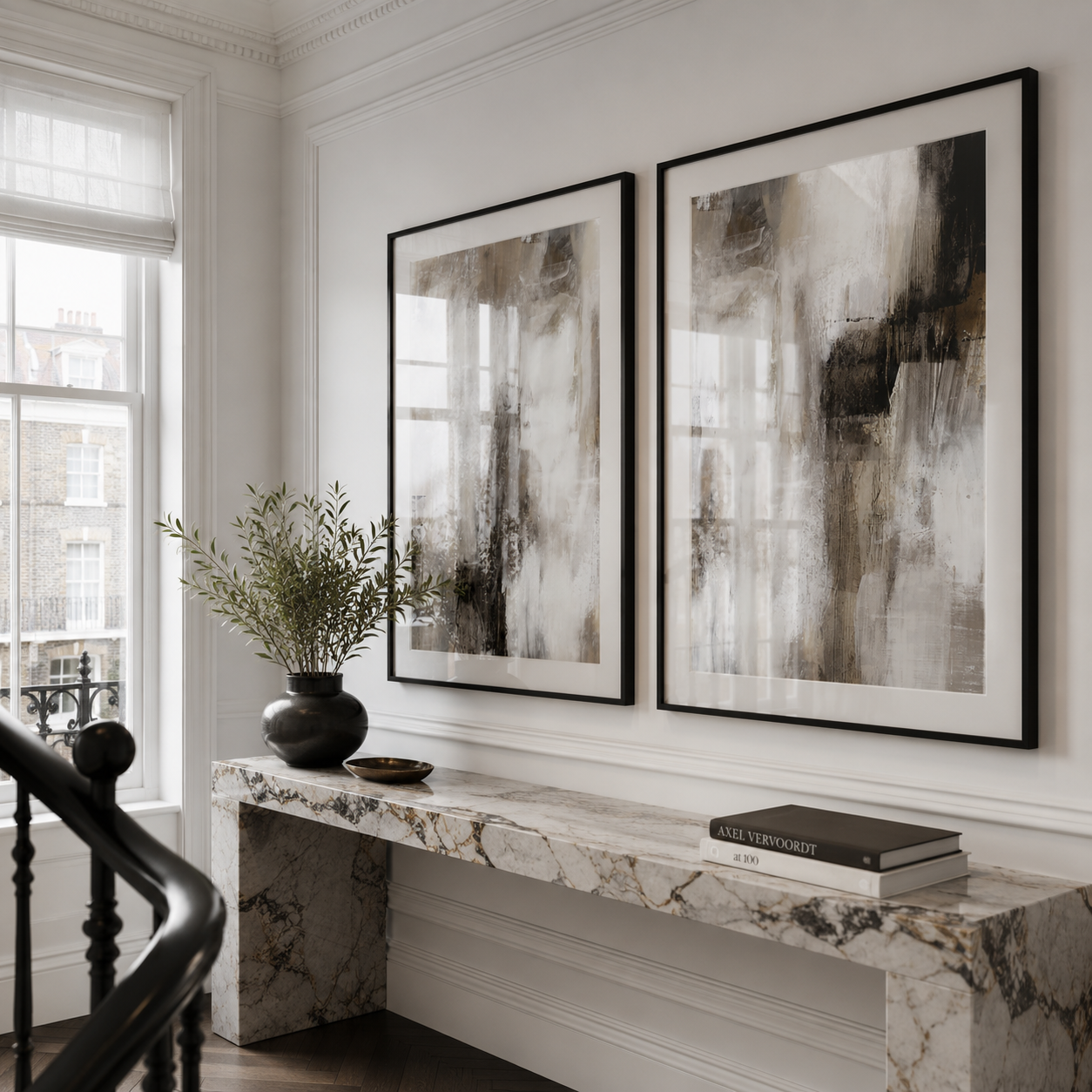 Two abstract paintings on a wall above a marble console table.
