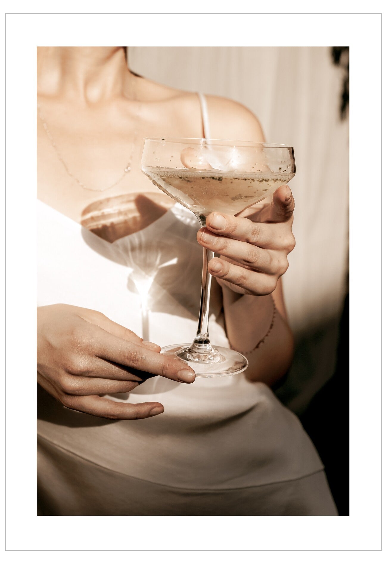 Person holding a cocktail glass with a blurred background