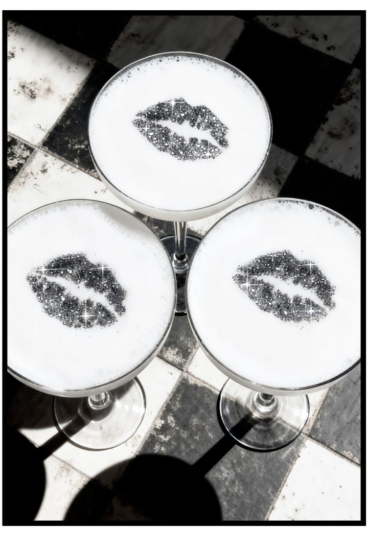 Three cocktail glasses with lip-shaped bubbles on a checkered floor.