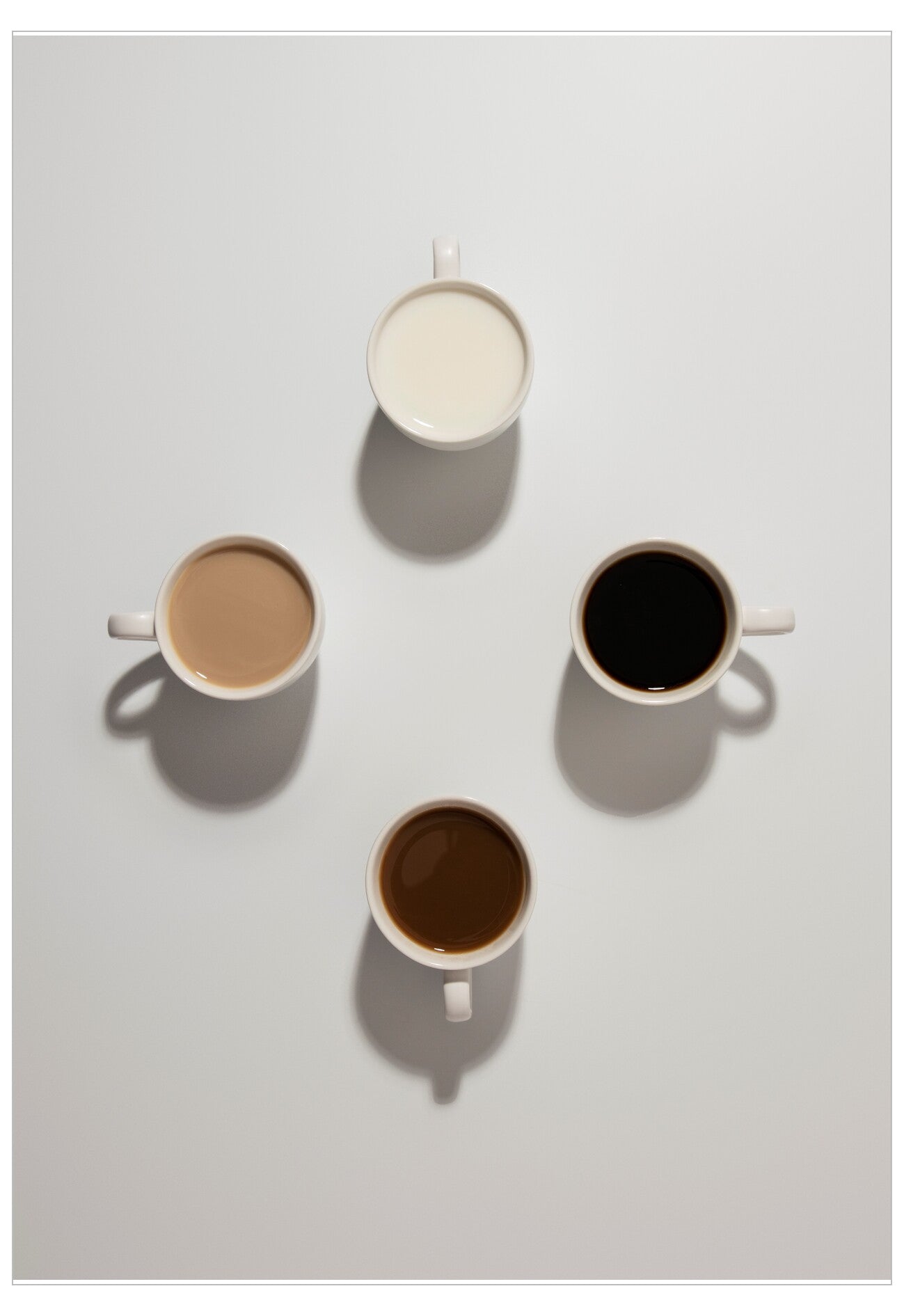 Four cups of different coffee types on a light gray background