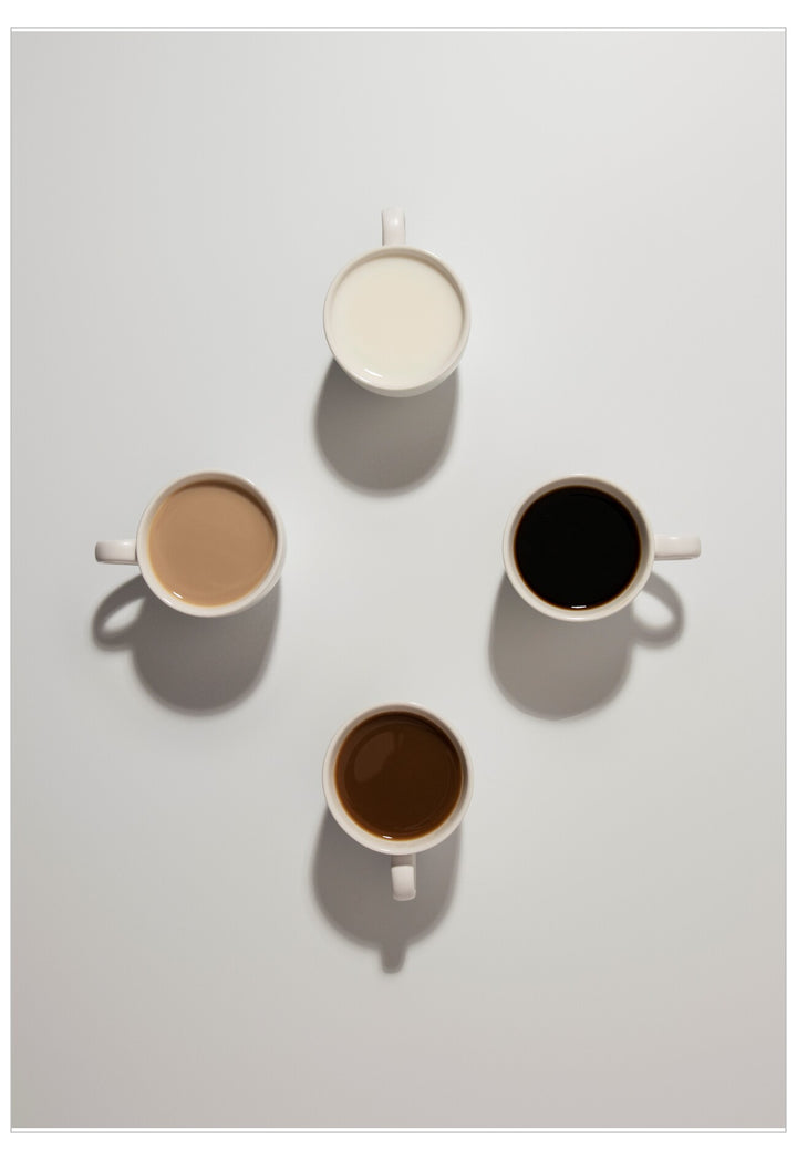 Four cups of different coffee types on a light gray background