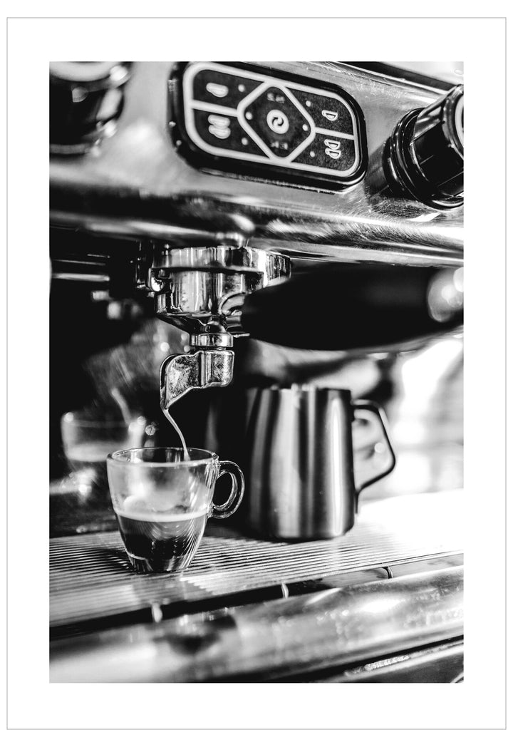 Espresso being brewed into a glass cup from an espresso machine.