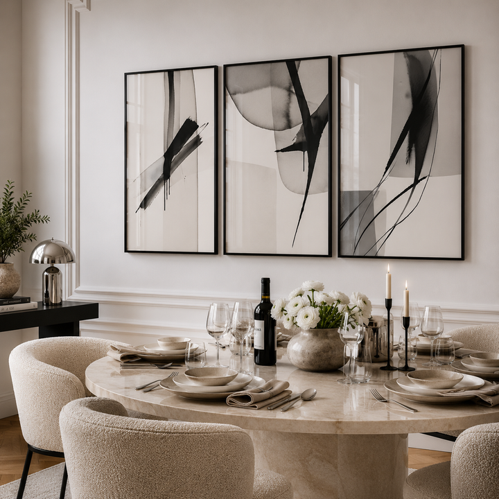 Dining room with a round table set for a meal, abstract art on the wall, and decorative elements.