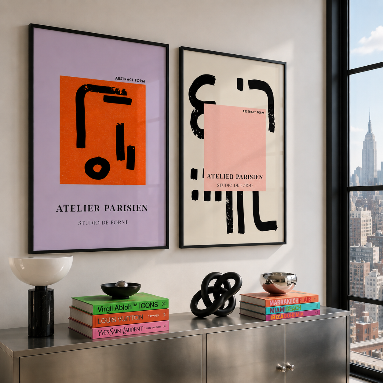 Two framed abstract artworks on a wall with books and decorative items below.