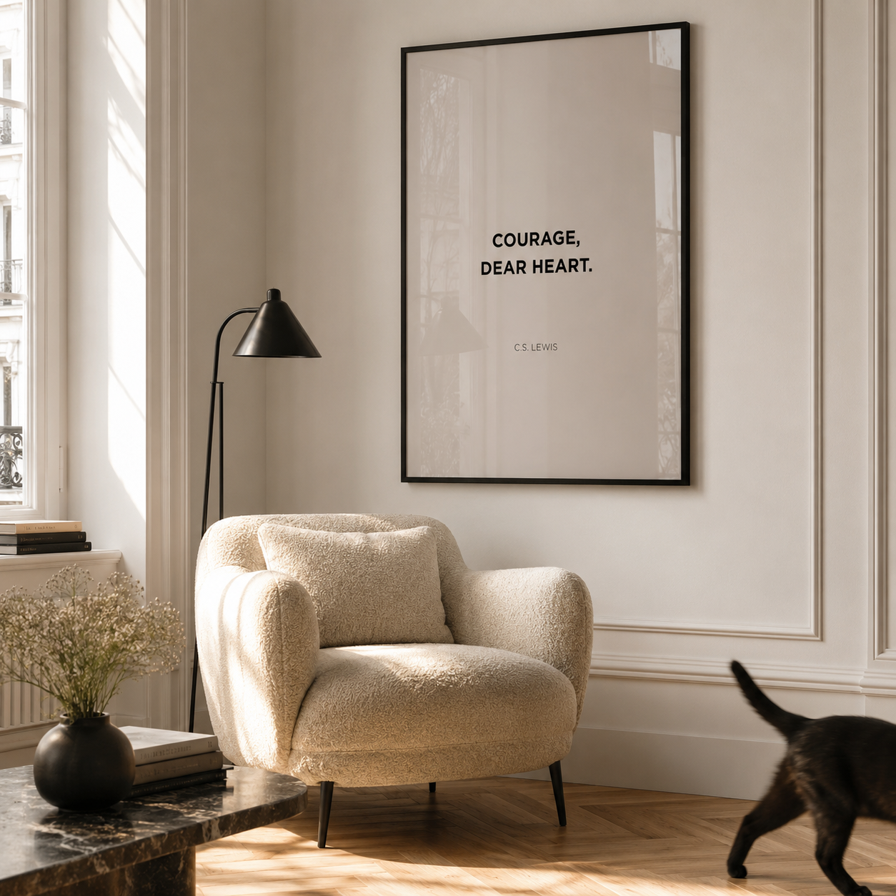 Beige armchair in a room with a framed quote on the wall and a cat walking by.