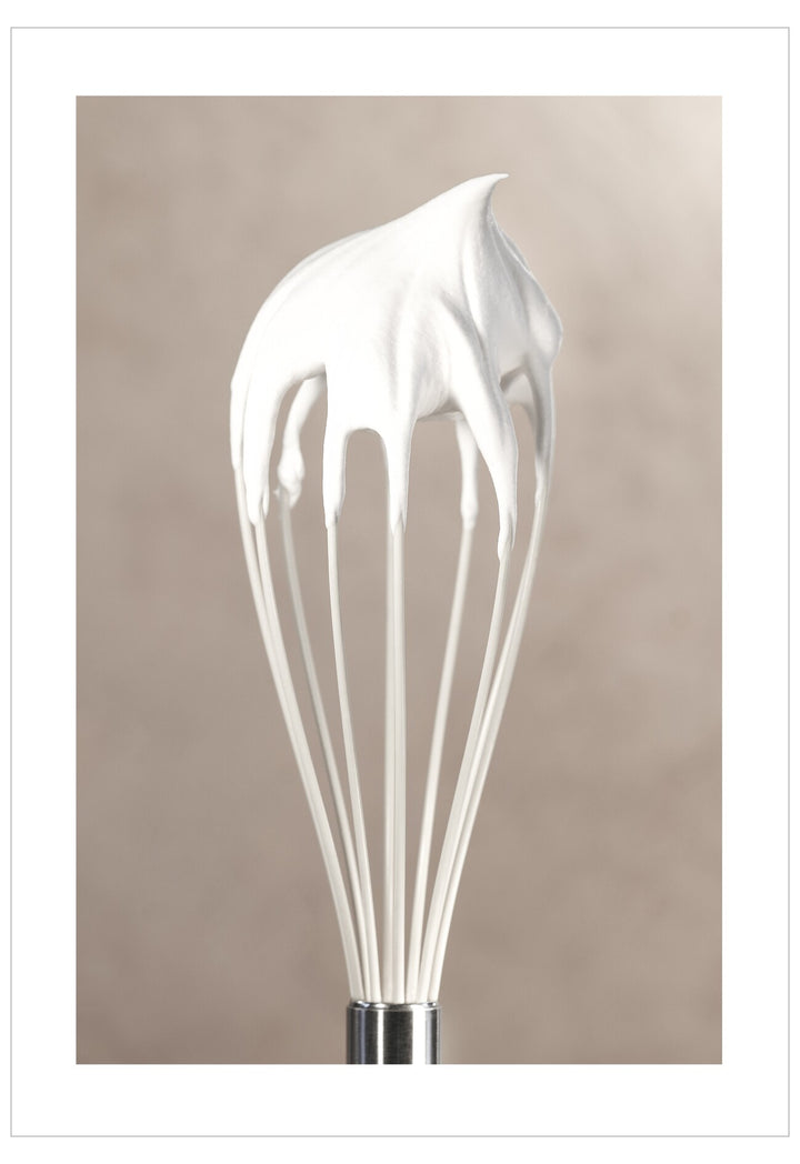 Whisk with whipped cream on a beige background