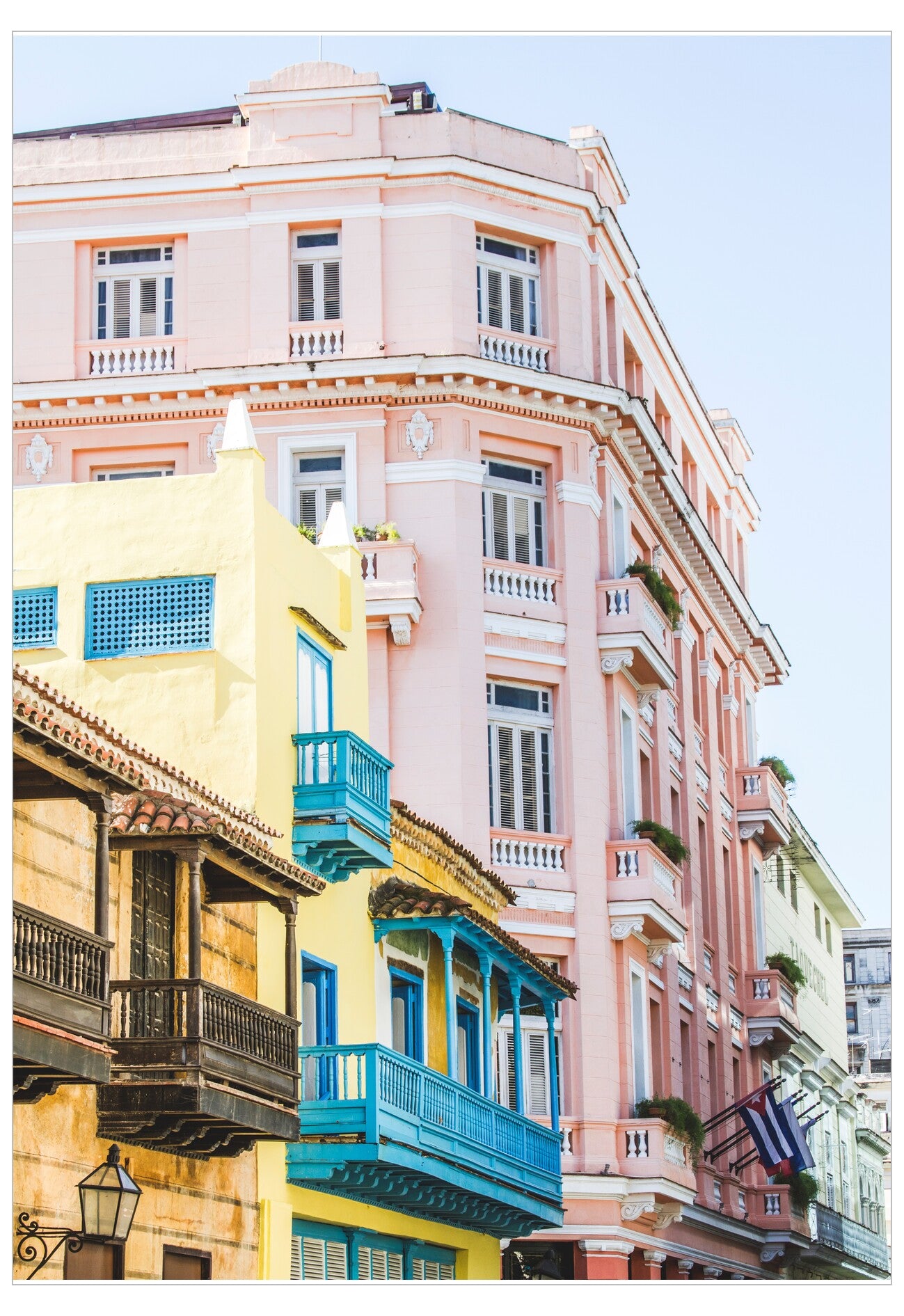 Colorful building facades with balconies against a clear blue sky.