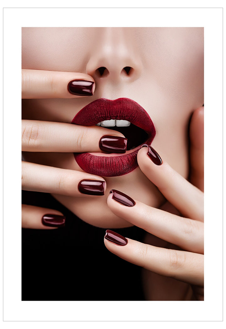 Close-up of a woman's face with red lipstick and dark nail polish on a white background