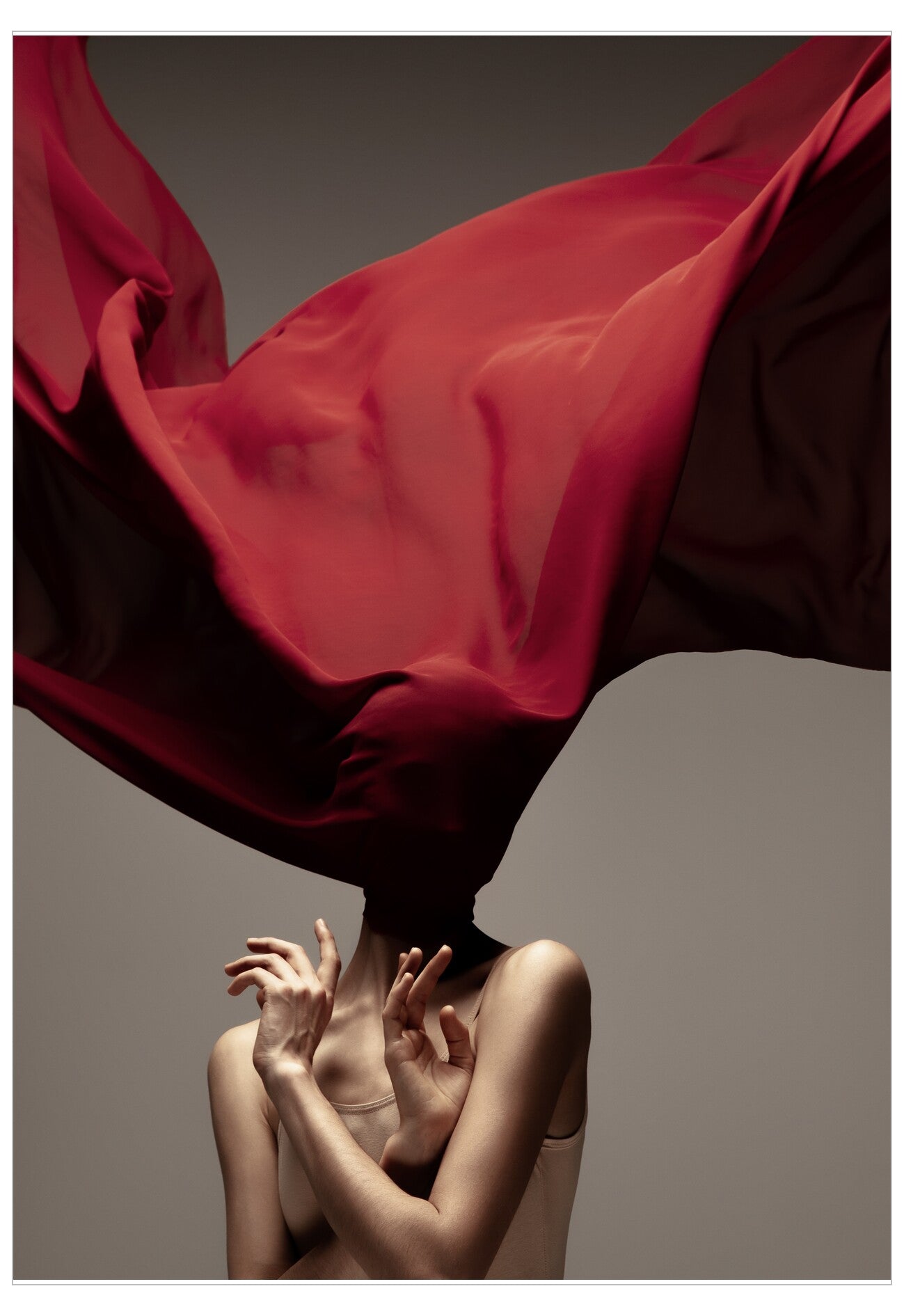 Person with a flowing red fabric over their head against a neutral background