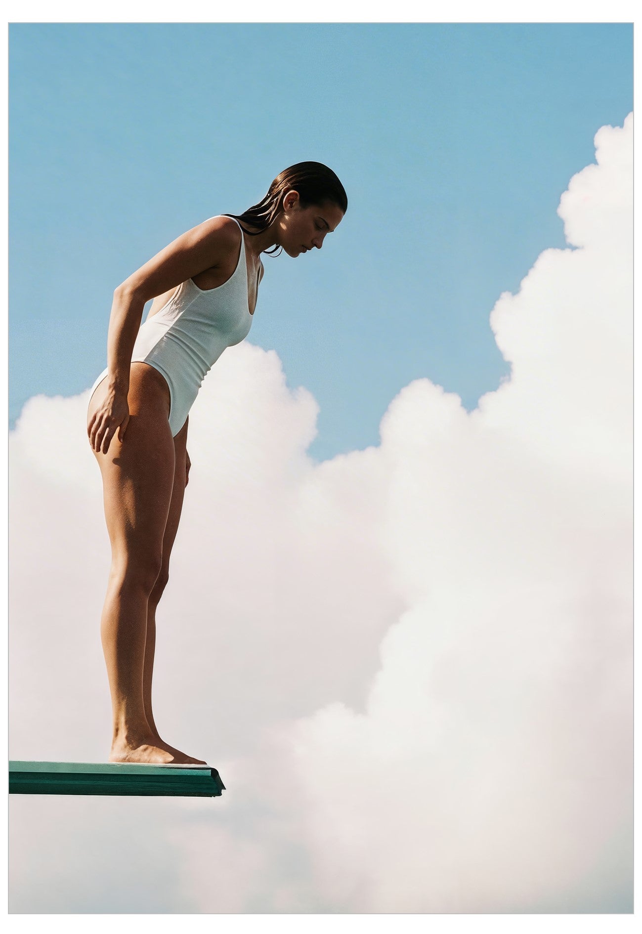 Person in a swimsuit standing on a diving board with smoke effects and a blue sky background