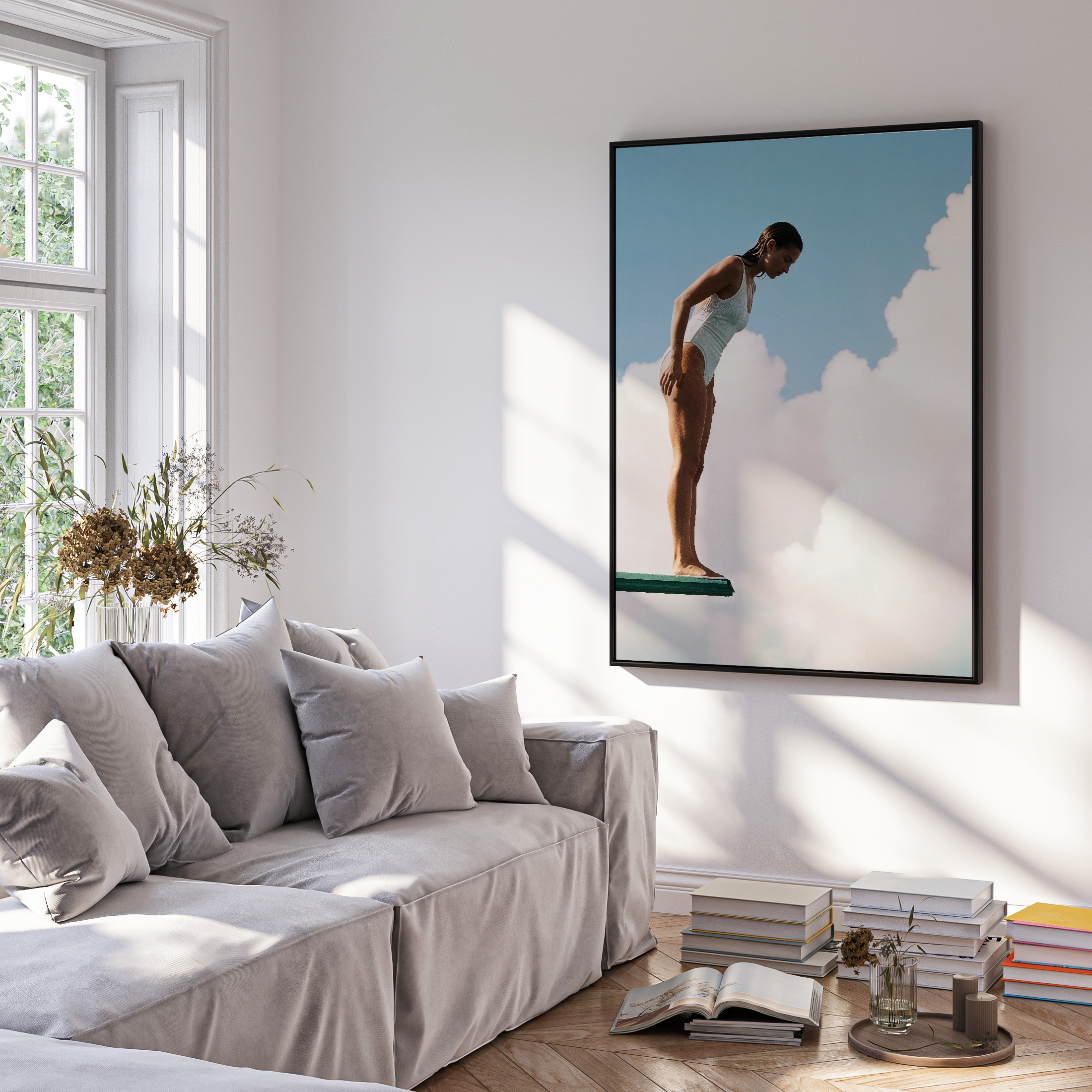 Living room with a gray sofa, framed artwork of a dancer, and a window with natural light.
