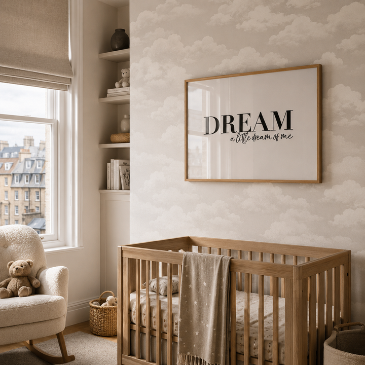 Nursery room with wooden crib, teddy bear, and framed quote on cloud-patterned wall.