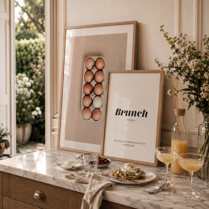 Brunch setting with plates, glasses, and flowers on a marble countertop.