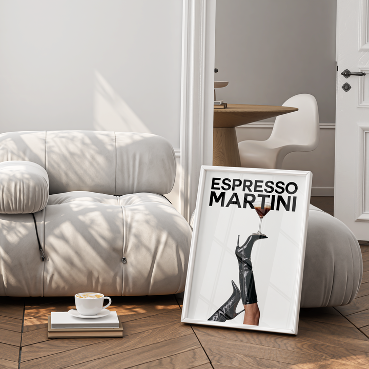 White armchair in a room with a framed picture of 'Espresso Martini' and a cup on a small table.