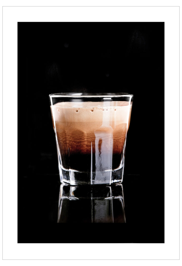 Glass of layered coffee on a black background