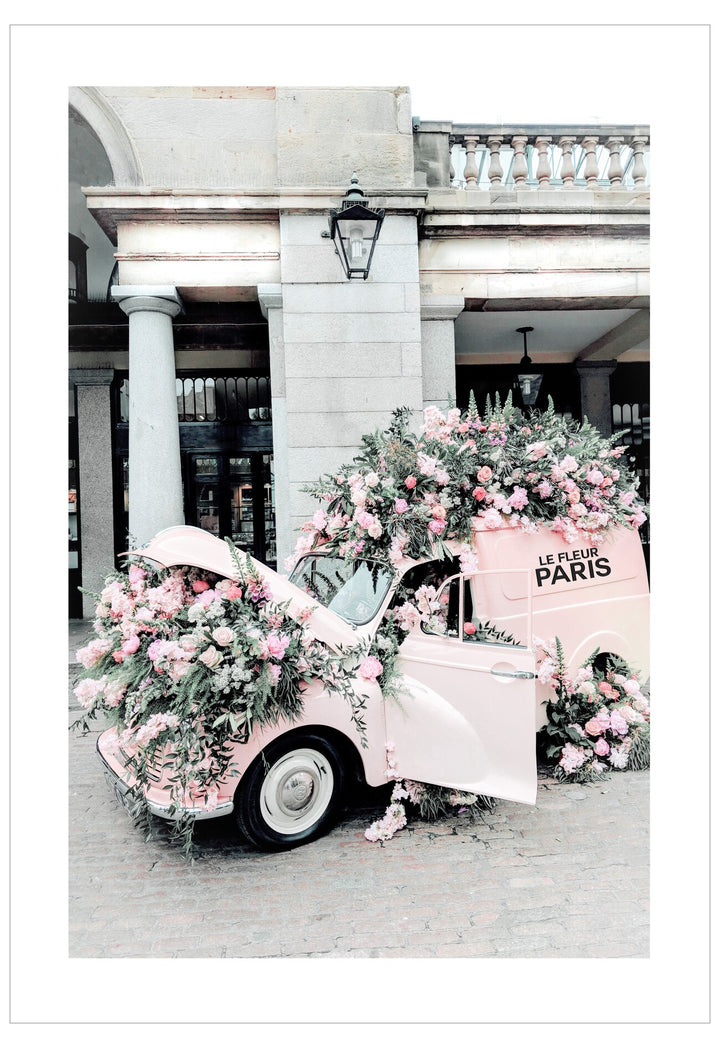 Pink car decorated with flowers in front of a classical building