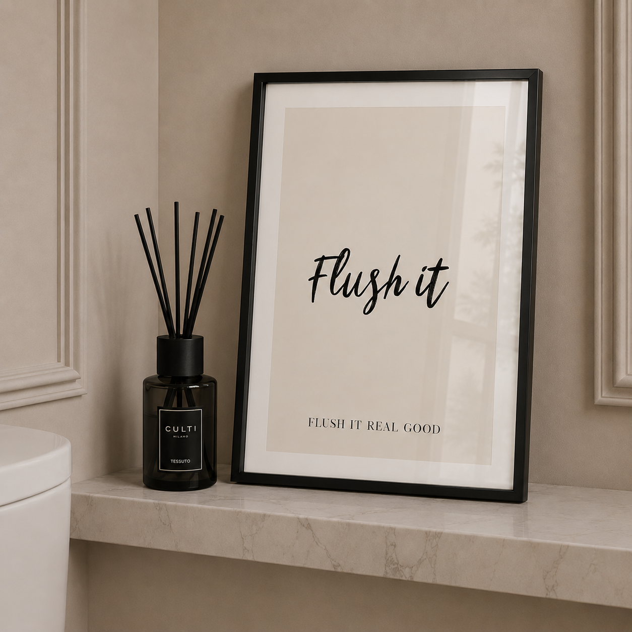 Framed print with 'Flush it' text on a bathroom shelf next to a diffuser.