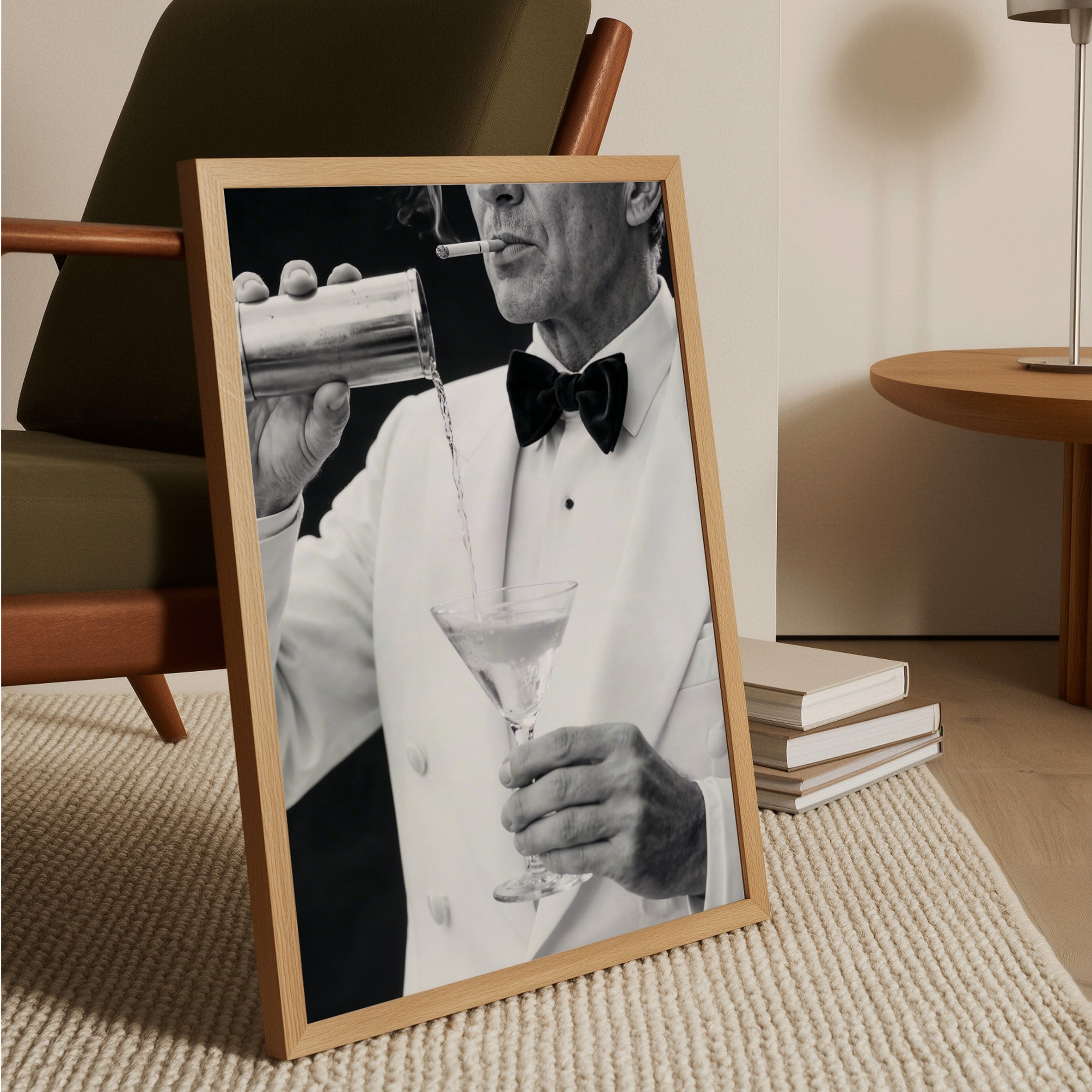 Framed black and white photo of a man in a tuxedo pouring a cocktail, placed on a textured surface.
